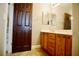 Bathroom featuring tile flooring, a vanity with sink, mirror and a dark wood door at 9144 Clear Sky Ave, Las Vegas, NV 89178