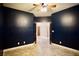 Bedroom with dark blue walls, ceiling fan, and neutral tile floors at 9144 Clear Sky Ave, Las Vegas, NV 89178