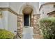 Charming front entryway with stone pillars and a dark-colored front door, surrounded by landscaped bushes at 9144 Clear Sky Ave, Las Vegas, NV 89178