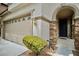 Inviting front entrance featuring stone accents, a covered porch, and an attached two-car garage on the side at 9144 Clear Sky Ave, Las Vegas, NV 89178