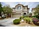 Inviting two-story home boasts a landscaped front yard, attached garage, and charming architectural details at 9144 Clear Sky Ave, Las Vegas, NV 89178