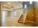 Spacious living room with tiled floors, staircase, a ceiling fan, and abundant natural light from multiple windows at 9144 Clear Sky Ave, Las Vegas, NV 89178
