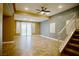 Open-concept living room with tile flooring, staircase, ceiling fan, and sliding glass door at 9144 Clear Sky Ave, Las Vegas, NV 89178