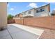 A backyard featuring a concrete patio area enclosed by a brick wall and desert landscaping at 928 Shades End Ave, North Las Vegas, NV 89081