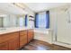 Bathroom with a tub, dual sinks, wood cabinets and a stand-up shower at 928 Shades End Ave, North Las Vegas, NV 89081