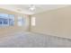 Spacious carpeted bedroom with a ceiling fan and bright natural light from large windows at 928 Shades End Ave, North Las Vegas, NV 89081