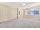 Bright, carpeted bedroom with a ceiling fan, and natural light from large windows at 928 Shades End Ave, North Las Vegas, NV 89081