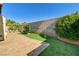 Beautiful backyard with a stone patio, green lawn, and privacy wall at 931 Highland Trails Ave, Henderson, NV 89015