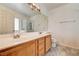 Bathroom with double sinks, a large mirror, and tile flooring at 931 Highland Trails Ave, Henderson, NV 89015