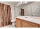 A bathroom featuring a shower with floral curtain, a white toilet, and wooden cabinets at 931 Highland Trails Ave, Henderson, NV 89015