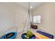 Bright bedroom featuring a playful hanging chair and a storage chest at 931 Highland Trails Ave, Henderson, NV 89015