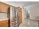 Spacious kitchen with stainless steel refrigerator, wood cabinets, and tile flooring at 931 Highland Trails Ave, Henderson, NV 89015