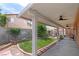 Inviting backyard featuring a covered patio, a lush lawn, landscaped garden beds, and a seating area at 9329 Mountain Cliffs Ave, Las Vegas, NV 89129