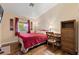 Cozy bedroom with wood floors, a comfortable bed, a window with natural light, and a desk area at 9329 Mountain Cliffs Ave, Las Vegas, NV 89129