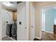 Functional laundry room features modern washer and dryer set, storage cabinets, and a connecting door to another room at 9329 Mountain Cliffs Ave, Las Vegas, NV 89129