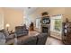 Cozy living room with a fireplace, vaulted ceilings, and natural light from the window at 9329 Mountain Cliffs Ave, Las Vegas, NV 89129