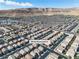 Wide aerial view of a residential neighborhood with many homes and streets, surrounded by mountains in the distance at 9713 Kampsville Ave, Las Vegas, NV 89148