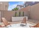 The backyard has a concrete patio, planters, and wooden chairs, perfect for outdoor enjoyment at 9713 Kampsville Ave, Las Vegas, NV 89148