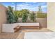This backyard features a bench seating area with trees and greenery in the garden at 9713 Kampsville Ave, Las Vegas, NV 89148