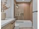 Modern bathroom with a beautiful wood accent wall, glass enclosed bathtub, and sleek fixtures at 9713 Kampsville Ave, Las Vegas, NV 89148