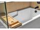 A close-up of a modern bathtub with a wooden tray, showcasing its sleek design and relaxing features at 9713 Kampsville Ave, Las Vegas, NV 89148