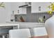 Modern kitchen features white cabinets, a gray backsplash, and stainless steel appliances at 9713 Kampsville Ave, Las Vegas, NV 89148