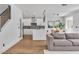Stylish living room with hardwood floors, gray sofa, and seamless transition to the kitchen at 9713 Kampsville Ave, Las Vegas, NV 89148