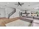 Cozy living room with hardwood floors, gray sofa, and view of modern kitchen and staircase at 9713 Kampsville Ave, Las Vegas, NV 89148