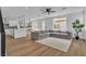 Open-concept living room with hardwood floors, gray sofa, and a modern kitchen in the background at 9713 Kampsville Ave, Las Vegas, NV 89148