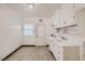 Functional utility room with vintage white cabinets, and a window near the exit door at 103 W Victory Rd, Henderson, NV 89015