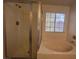 Bathroom showcases a glass shower, and a soaking tub under a window for a relaxing experience at 1030 Country Skies Ave, Las Vegas, NV 89123