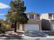 Two-story home featuring a desert landscaped front yard, a large tree, and a two-car garage at 1030 Country Skies Ave, Las Vegas, NV 89123
