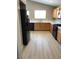 A spacious kitchen with light wood cabinets and modern black appliances and flooring at 10342 Spider Rock Ave, Las Vegas, NV 89135