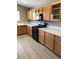 Modern kitchen with wood cabinets, black appliances and wood-look flooring at 10342 Spider Rock Ave, Las Vegas, NV 89135