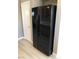 A black refrigerator with a water dispenser is shown near a white door at 10342 Spider Rock Ave, Las Vegas, NV 89135