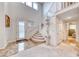 Bright foyer featuring a grand staircase, marble floors, and a decorative front door at 1367 Minuet St, Henderson, NV 89052