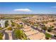 High aerial view of a community near a pond featuring tiled roofs, desert landscaping, and paved roads at 1433 Overseer Ave, Henderson, NV 89074