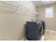 Laundry room featuring washer and dryer, storage shelf, and window with white shutters at 1433 Overseer Ave, Henderson, NV 89074