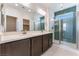 Modern bathroom with double sinks, large mirror, and walk-in shower with decorative tile at 1799 Passerine St, Las Vegas, NV 89138