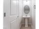 Clean and simple powder room with a pedestal sink, oval mirror, and neutral color scheme at 1799 Passerine St, Las Vegas, NV 89138