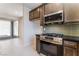 Modern kitchen with stainless steel stove, dark cabinets, and an adjacent outdoor view at 1799 Passerine St, Las Vegas, NV 89138