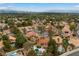 Expansive aerial view of a vibrant community with mature trees, sparkling pools, and stunning mountain views at 1990 Freeman Ct, Henderson, NV 89014