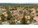 Expansive aerial view of a vibrant community with mature trees, sparkling pools, and stunning mountain views at 1990 Freeman Ct, Henderson, NV 89014