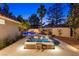 A beautifully landscaped backyard features a luxurious hot tub with inset lights, perfect for evening relaxation near the pool at 1990 Freeman Ct, Henderson, NV 89014