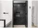 A stylish bathroom featuring a black tiled shower, sleek fixtures, and a white vanity, with neutral paint throughout at 1990 Freeman Ct, Henderson, NV 89014