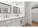 Modern bathroom featuring double sinks, sleek fixtures, stylish mirrors, and a glass-enclosed shower at 1990 Freeman Ct, Henderson, NV 89014