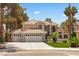 Charming two-story home with a three-car garage, well-manicured lawn, and mature palm trees at 1990 Freeman Ct, Henderson, NV 89014