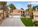 Expansive two-story home with a spacious driveway, three-car garage, and well-manicured landscaping at 1990 Freeman Ct, Henderson, NV 89014