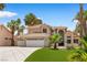 Charming two-story home with a three-car garage, well-manicured lawn, and mature palm trees at 1990 Freeman Ct, Henderson, NV 89014