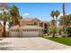 Charming two-story home with a three-car garage, well-manicured lawn, and mature palm trees at 1990 Freeman Ct, Henderson, NV 89014